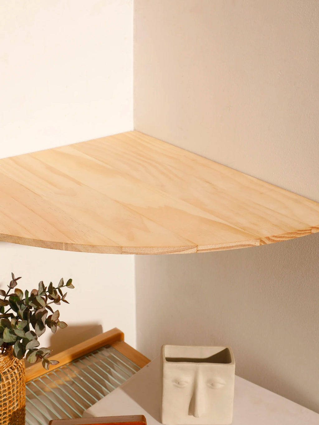Close-up of the scalloped wooden corner shelf surface showing wood grain and rounded edge