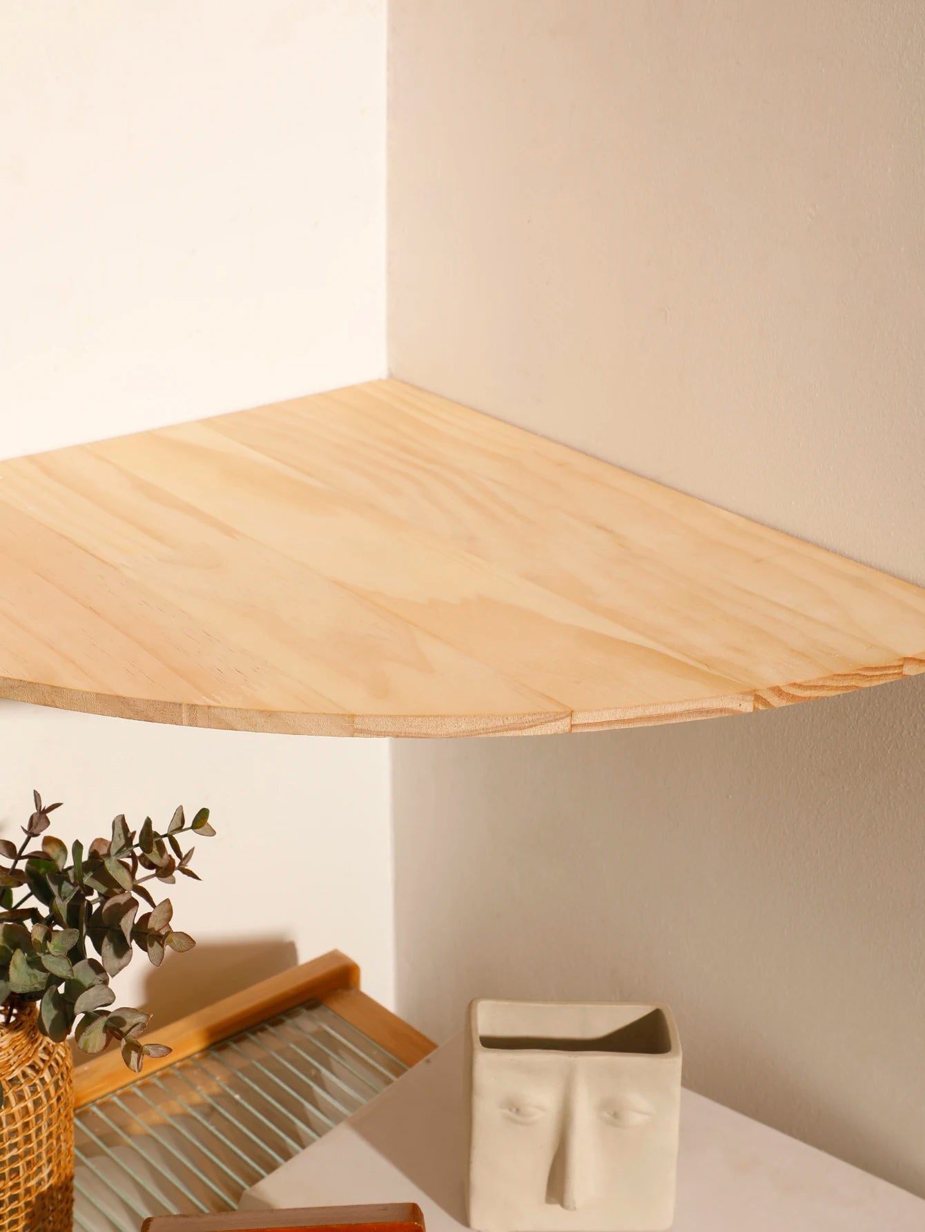 Close-up of the scalloped wooden corner shelf surface showing wood grain and rounded edge