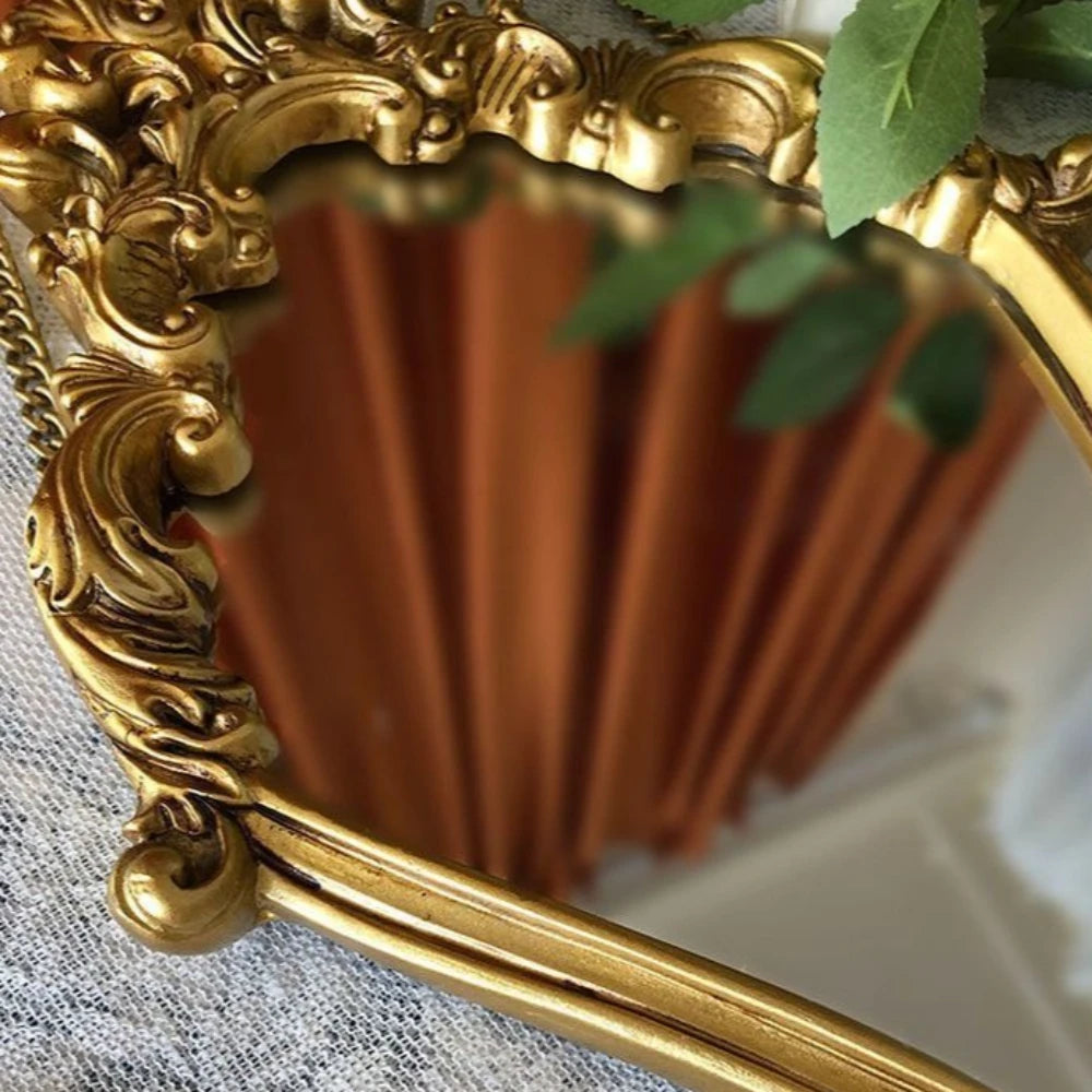 Detail of ornate gold vintage wall mirror frame with plant leaves