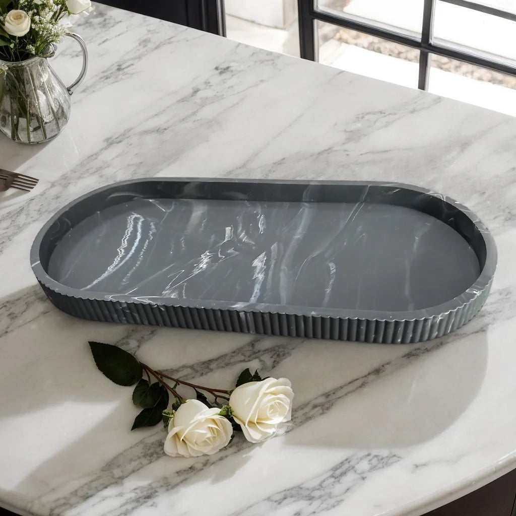 Black marble-patterned oval silicone tray displayed empty on a marble countertop