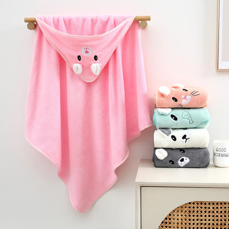 Pink cartoon animal hooded towel displayed on a wall hook next to other folded animal towels