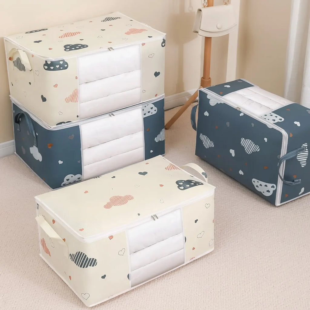 Assorted blue and beige cloud print foldable storage bags shown in a bedroom, showcasing both medium and large sizes.