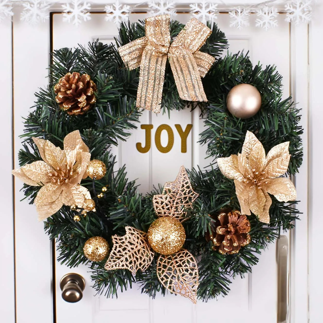 gold holiday wreath with lights and pine cones on white front door