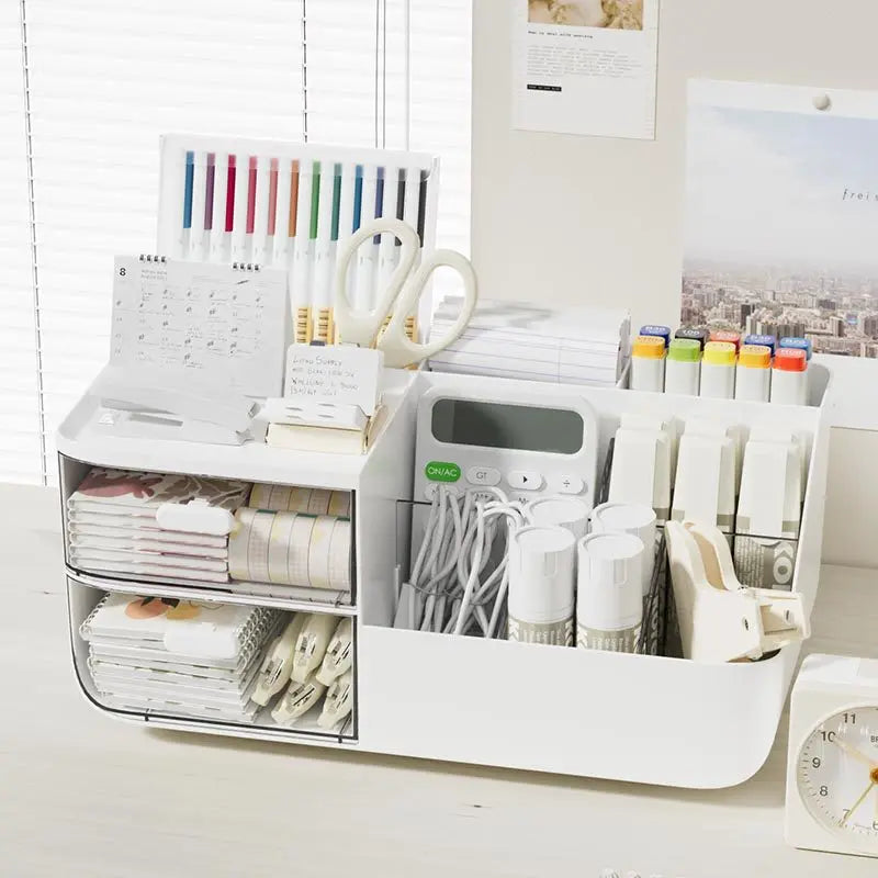 Divided desktop organizer box on a desk with stationery, cords, and notebooks sorted in each compartment