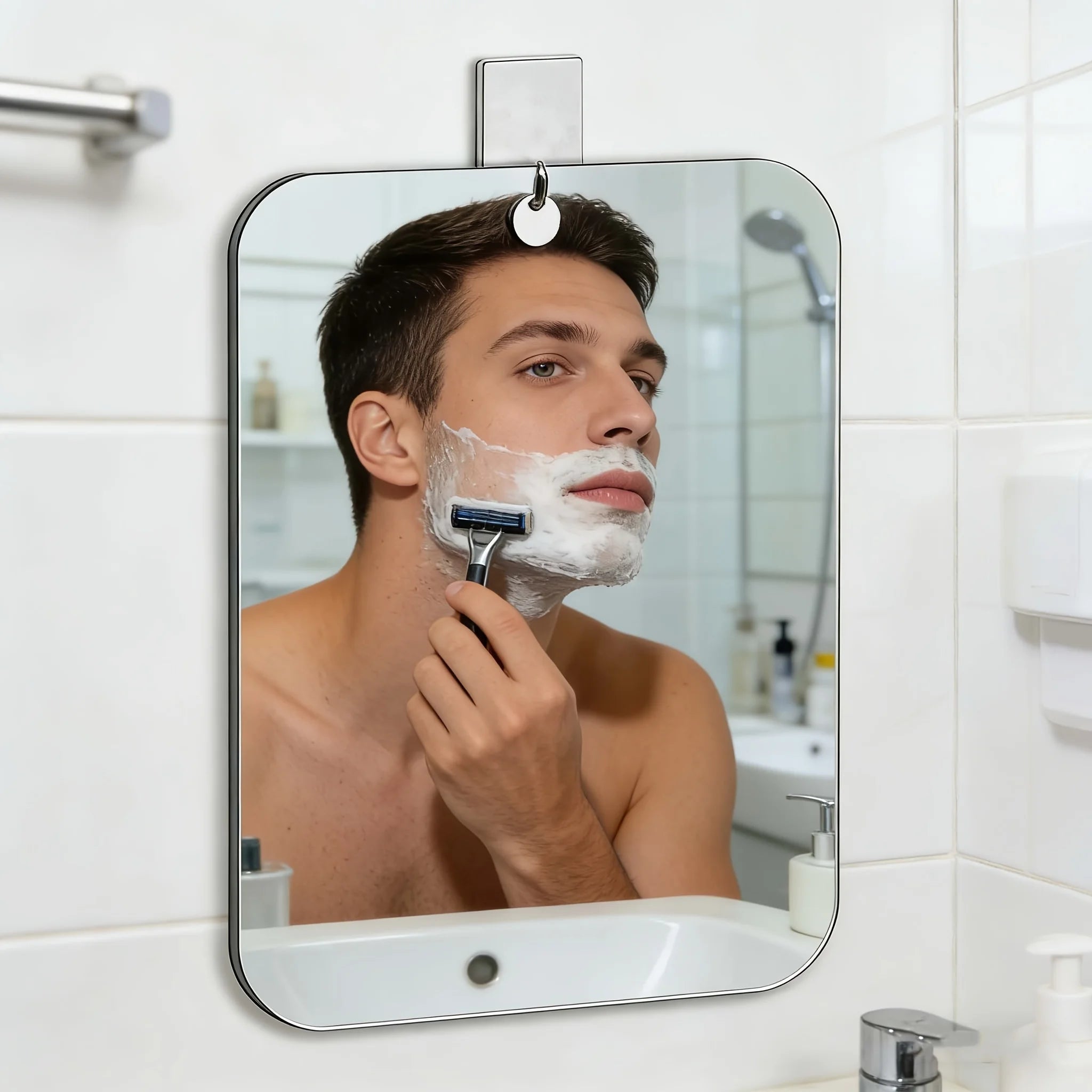 Acrylic wall mirror with hook above a bathroom sink, showing a person shaving