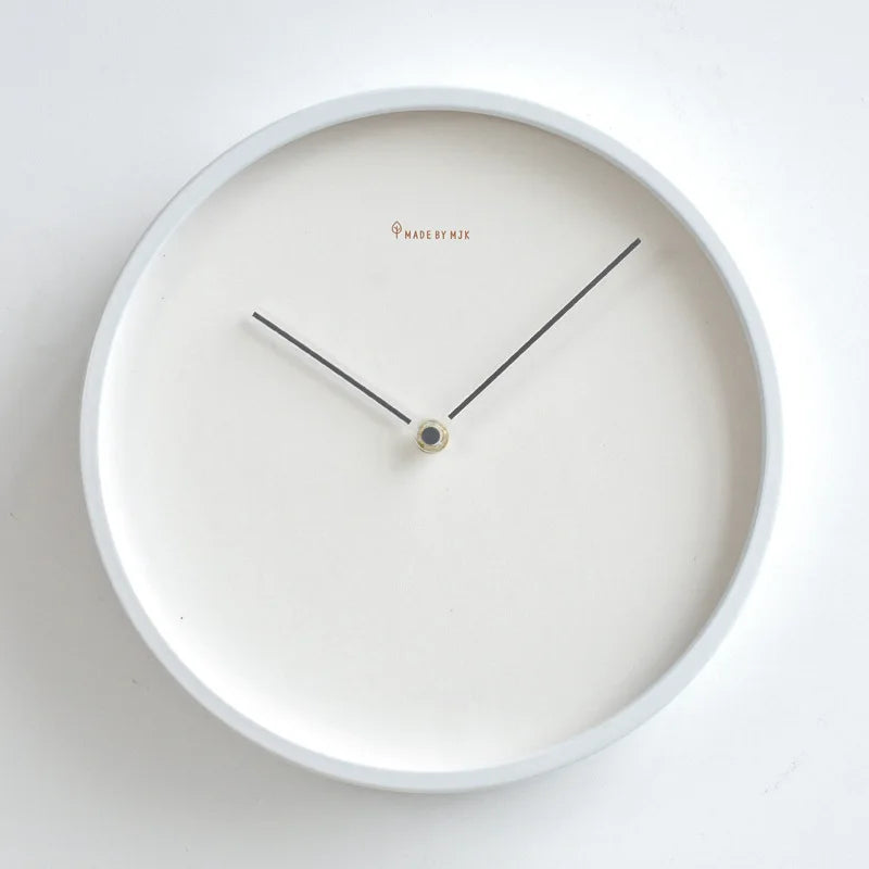 Minimalist metal wall clock with white face and thin black hands