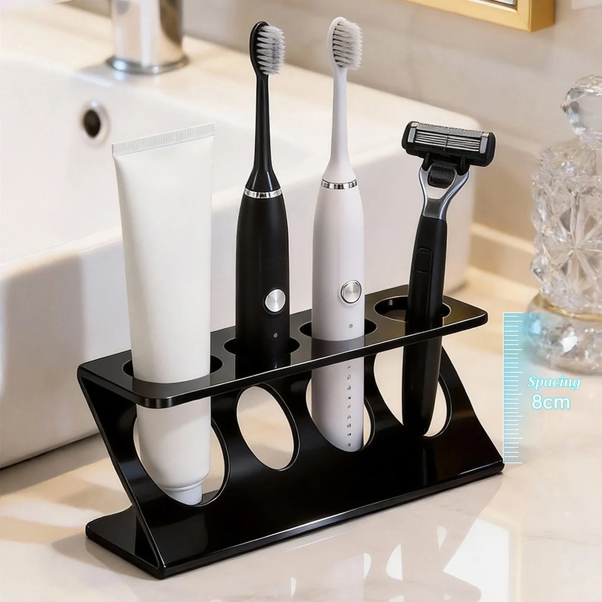 Black 4-slot plastic toothbrush holder with electric toothbrushes, razor, and toothpaste on a bathroom sink