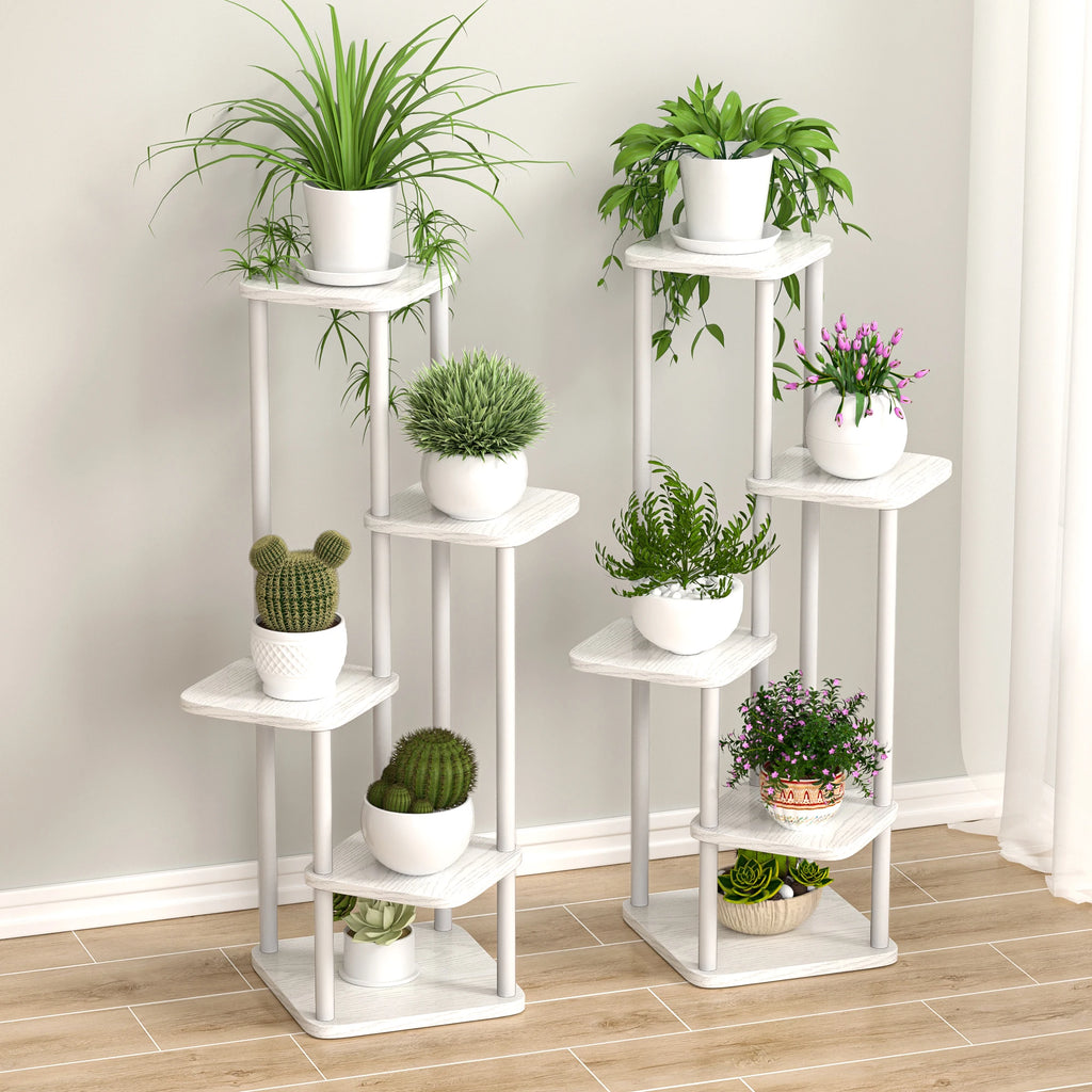 Two white wooden multi-tier plant stands with potted plants in a living room corner
