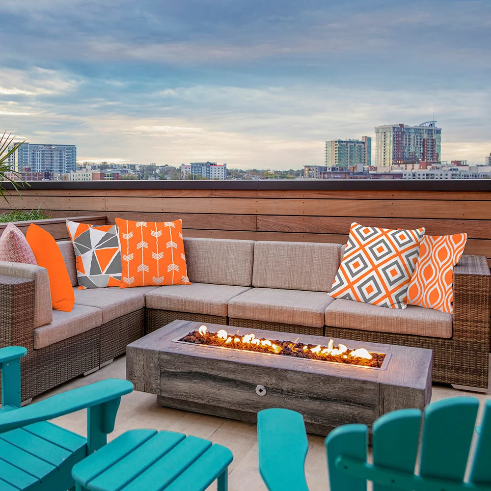 Contemporary geometric print outdoor cushion covers on a patio sectional, styled with orange and gray patterns