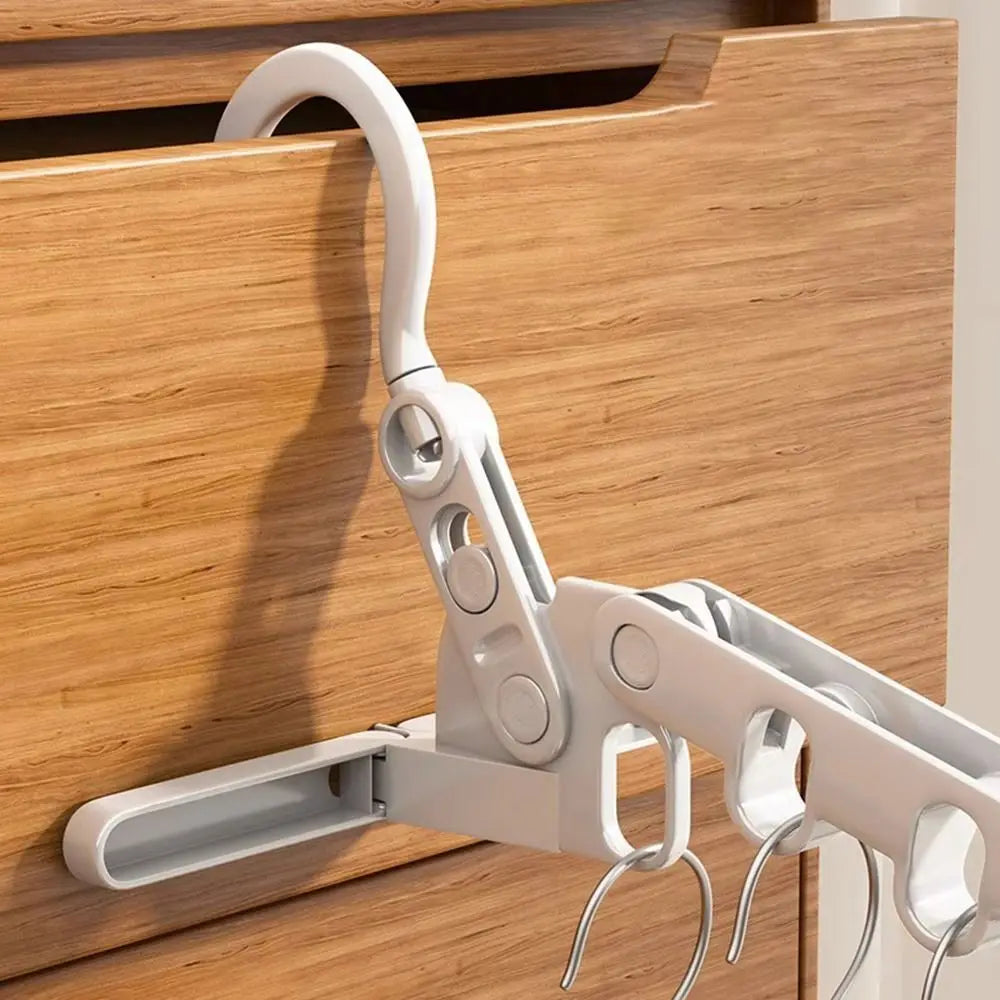 Foldable five-hole clothes drying rack hooked over a wooden door edge