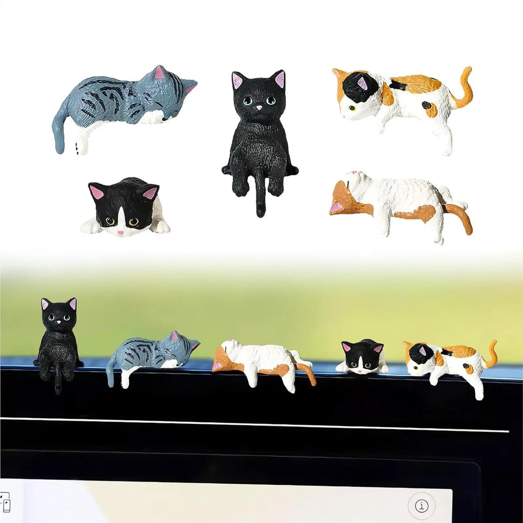 Mini cat figurines displayed on a monitor edge for desk or workspace decoration
