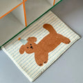 Striped fleece bathroom mat with brown cartoon puppy print placed near a shelf