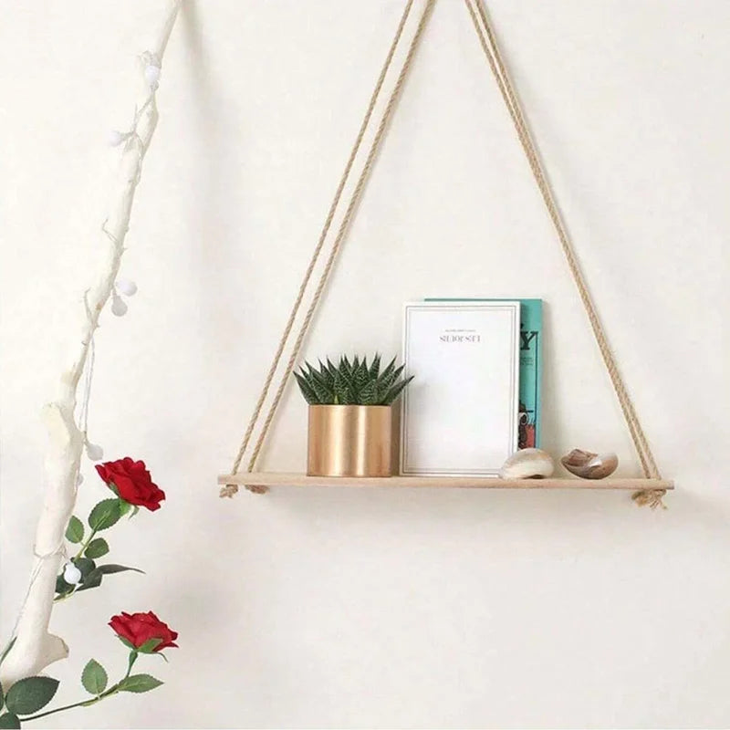 Single beige rope hanging wall shelf with a small plant and books, wall accent