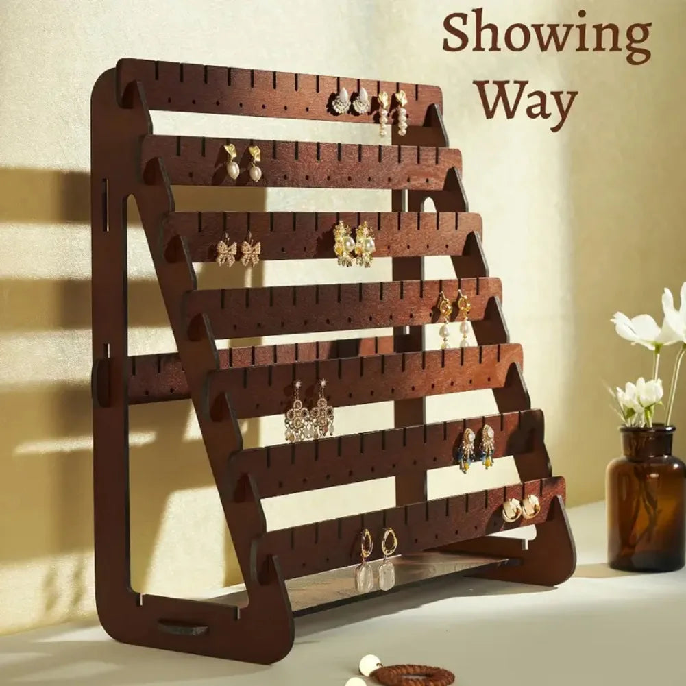 wooden earring display stand on a tabletop with earrings neatly organized, styled next to a vase