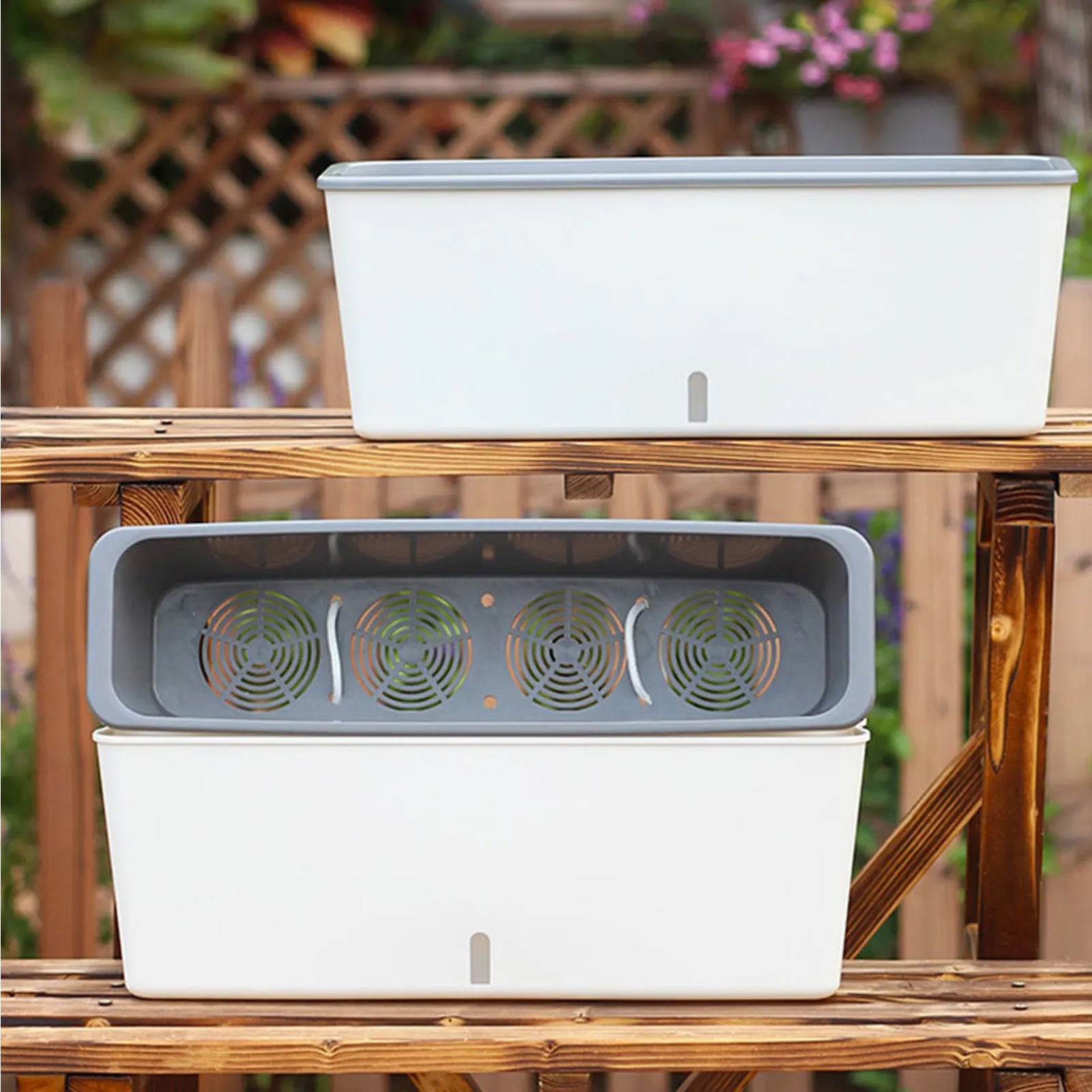 Two modern white self-watering planter boxes with water level indicators shown on an outdoor shelf