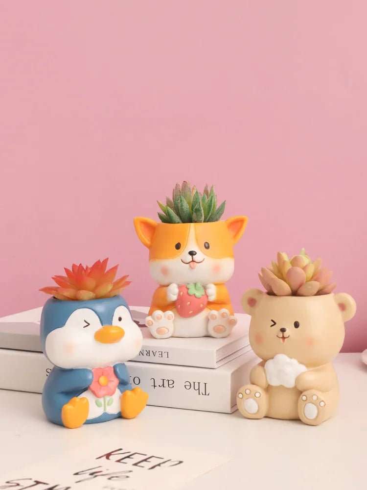 Penguin, Corgi, and Bear animal resin planters with succulents on books