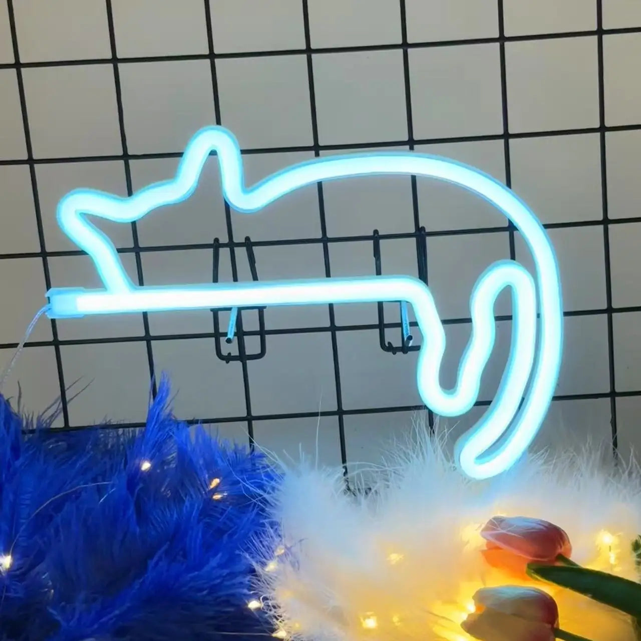 Blue cat-shaped LED neon wall light displayed on a grid wall with soft decor