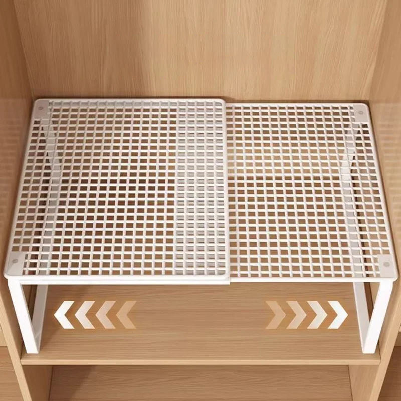 White adjustable steel shelf divider expanded on a wood closet shelf, shown from above