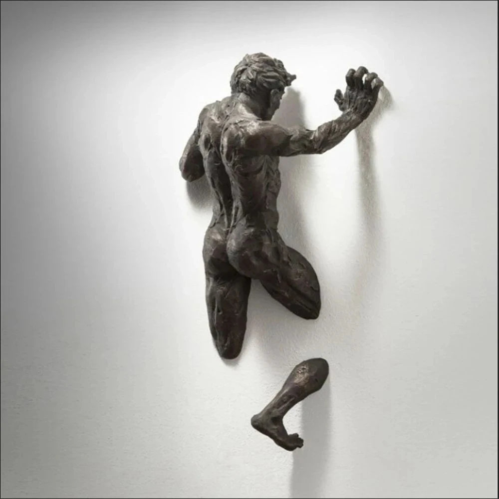 Imitation copper resin climbing man wall sculpture shown mounted on a white wall