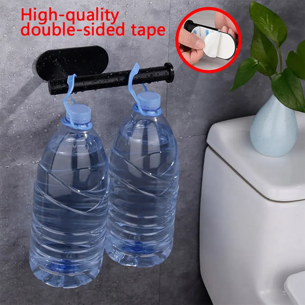 Black adhesive holder supporting two large water bottles next to a toilet, demonstrating adhesive strength