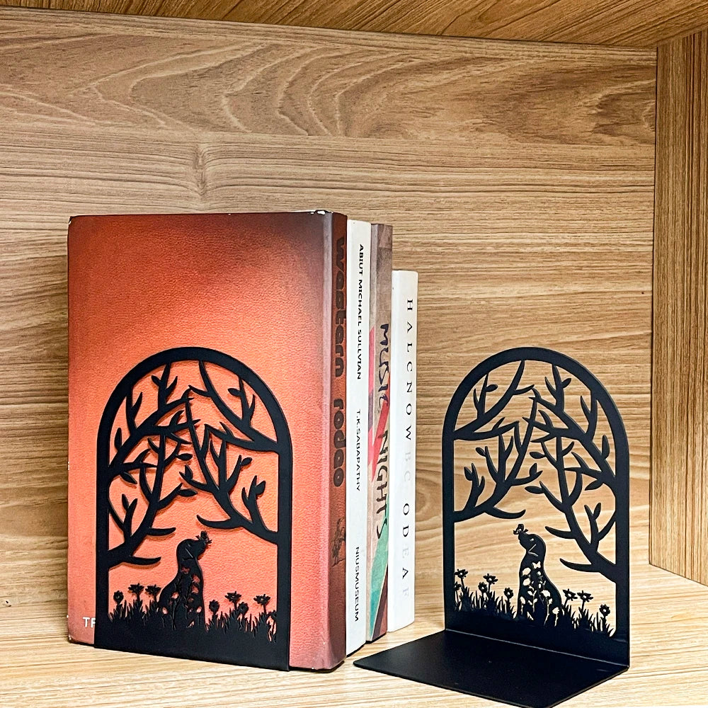 Metal bookends with cat and dog silhouettes holding up books on a wooden shelf