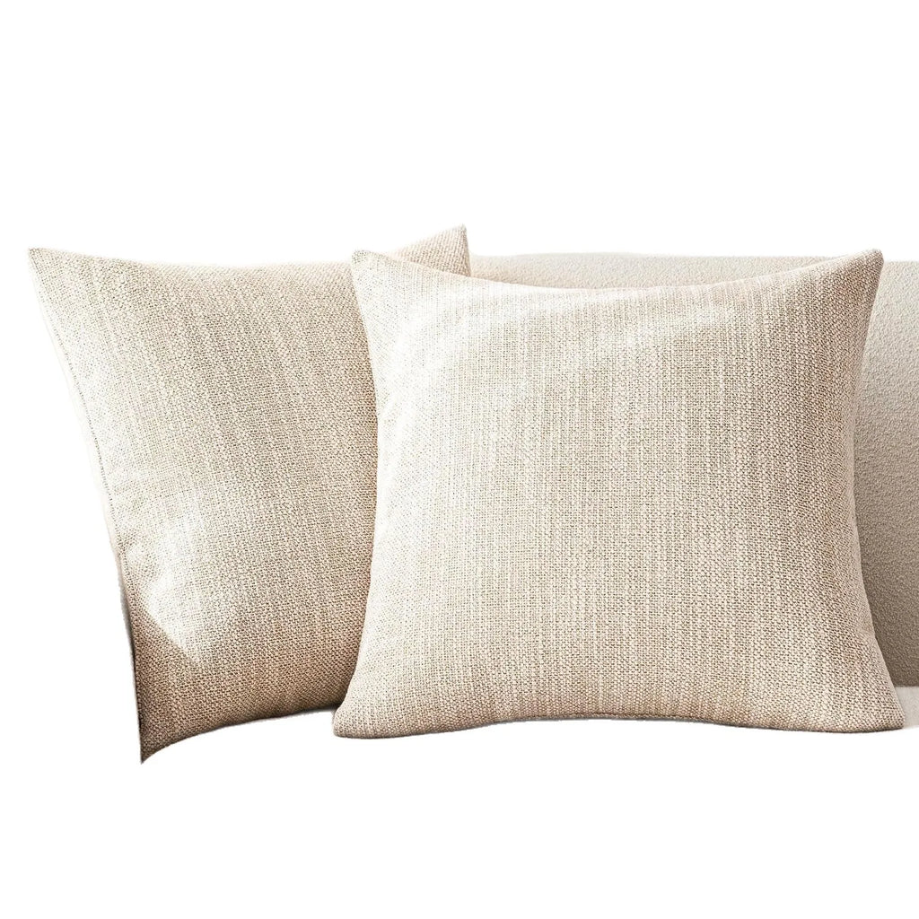 Pair of ivory chenille woven pillow covers on a neutral sofa