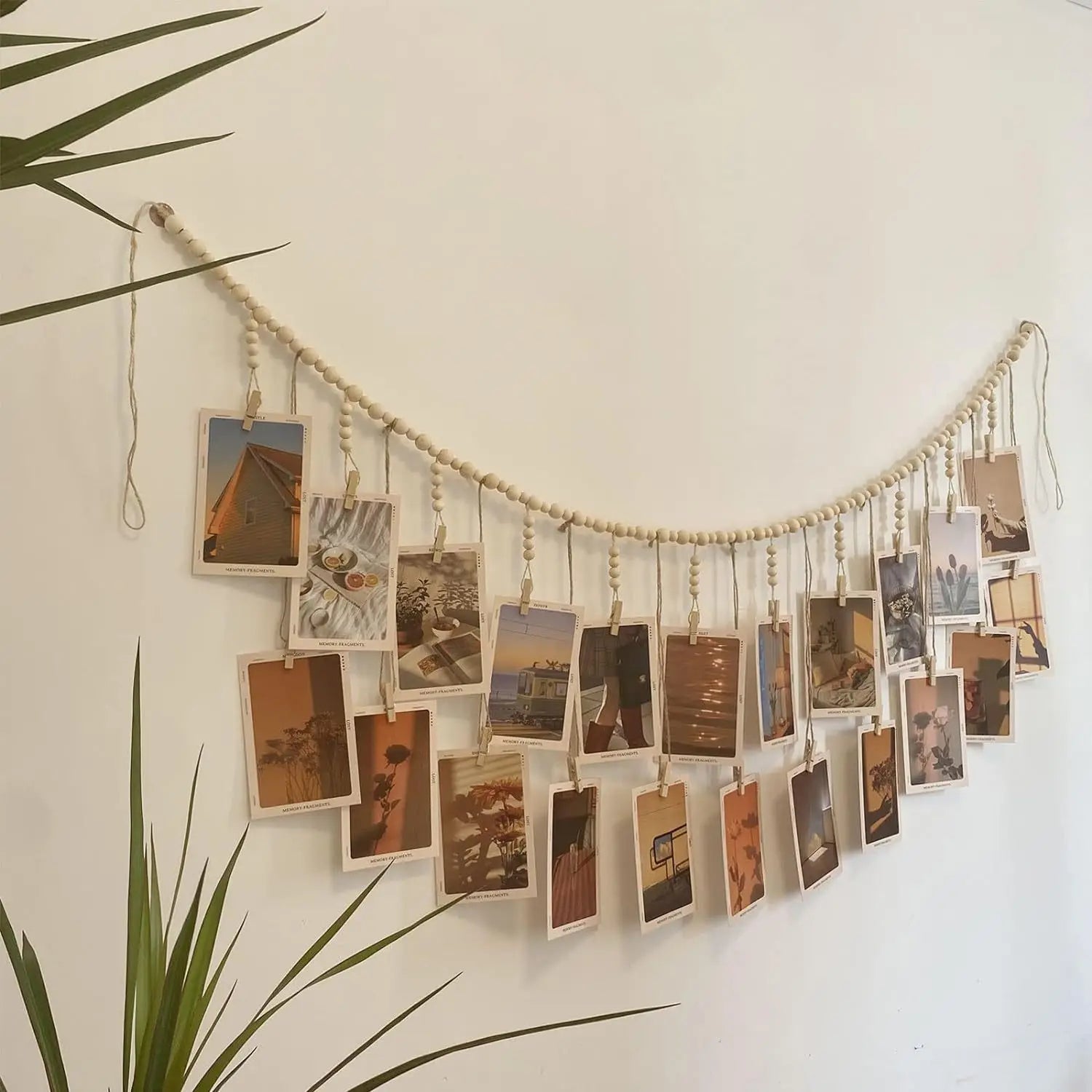 natural wood bead garland photo display hanging on a wall with postcards
