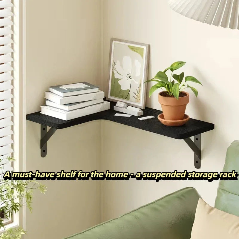 Black L-shaped wood corner wall shelf above a sofa, displaying books and a potted plant by a window