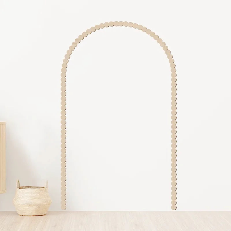 Scalloped wooden wall arch frame installed on a plain white wall, styled with a natural basket in a minimalist room