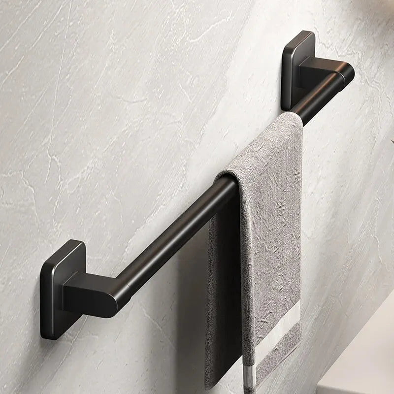 wall-mounted black aluminum towel rack with a single towel in a bathroom