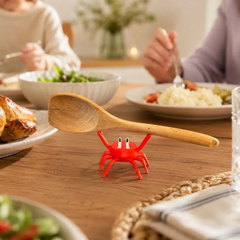 Red crab utensil holder supporting a spoon on a dining table setting