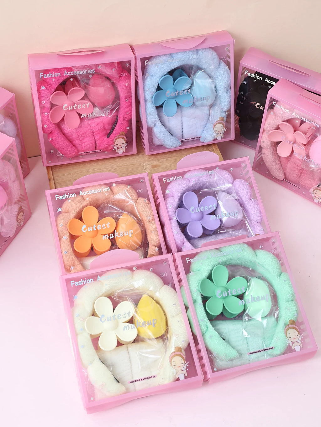 Variety of spa headband, wristband, and flower hair clip sets displayed in gift boxes