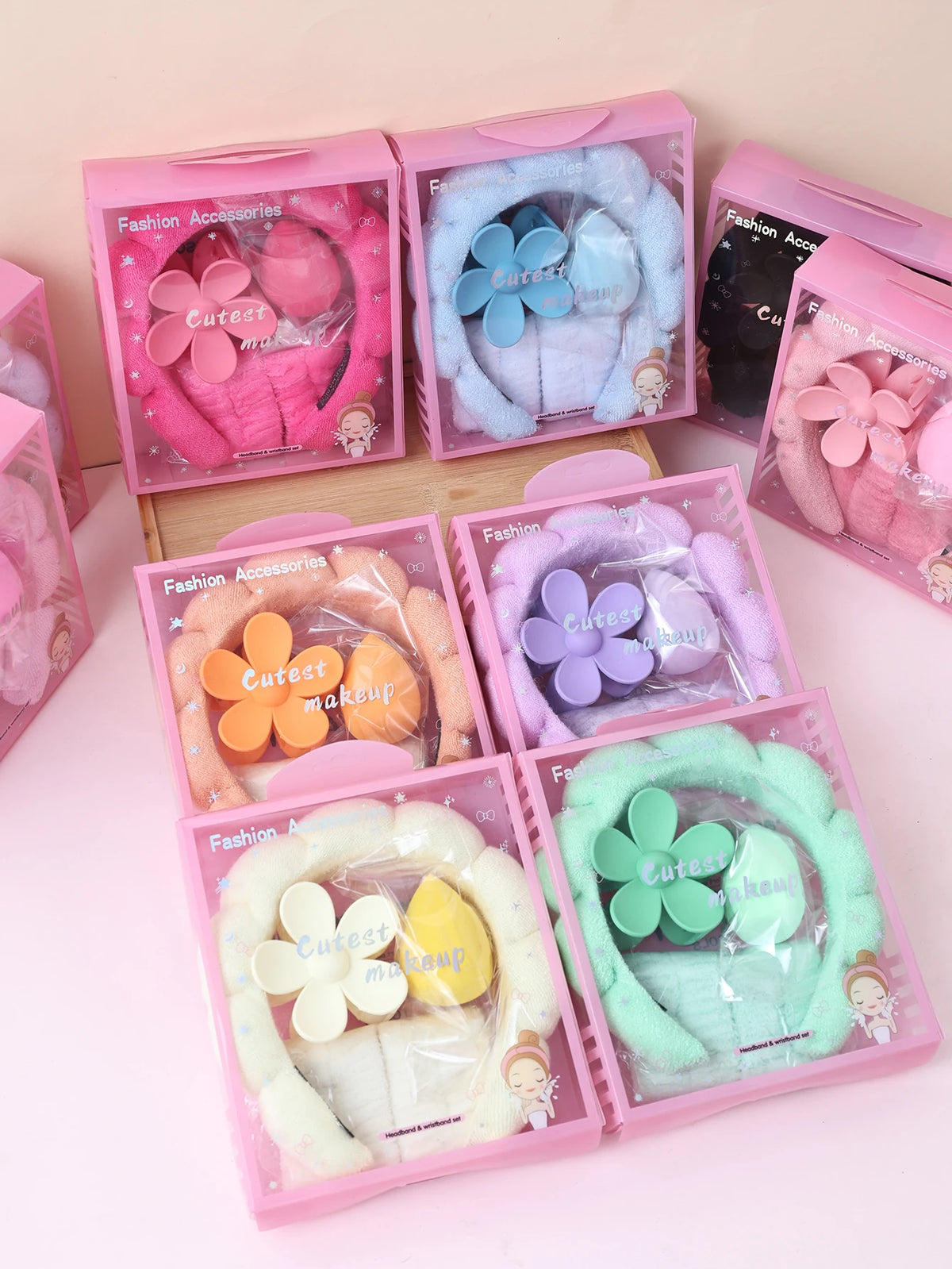 Variety of spa headband, wristband, and flower hair clip sets displayed in gift boxes