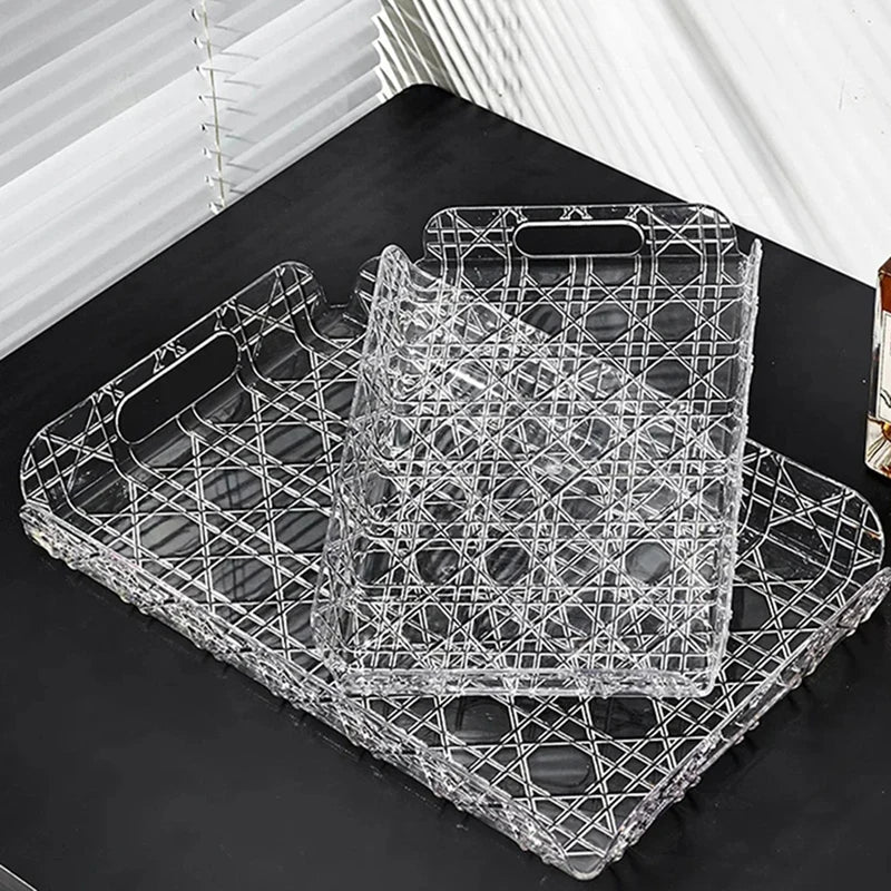 Two transparent rectangular trays stacked for storage on a surface with light from a window