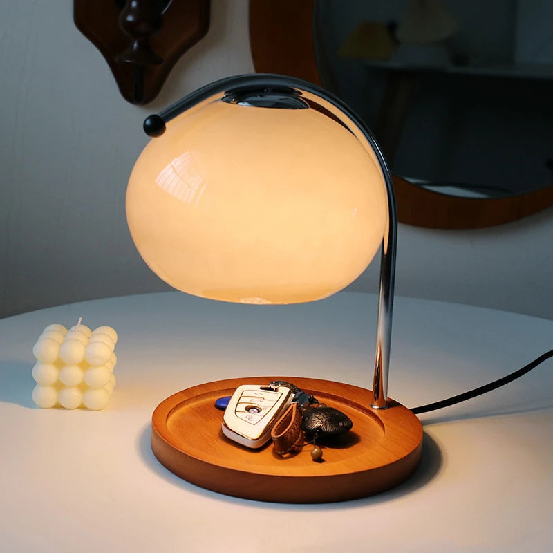 Glass candle warmer lamp used as a key tray on a round table, lit with soft glow