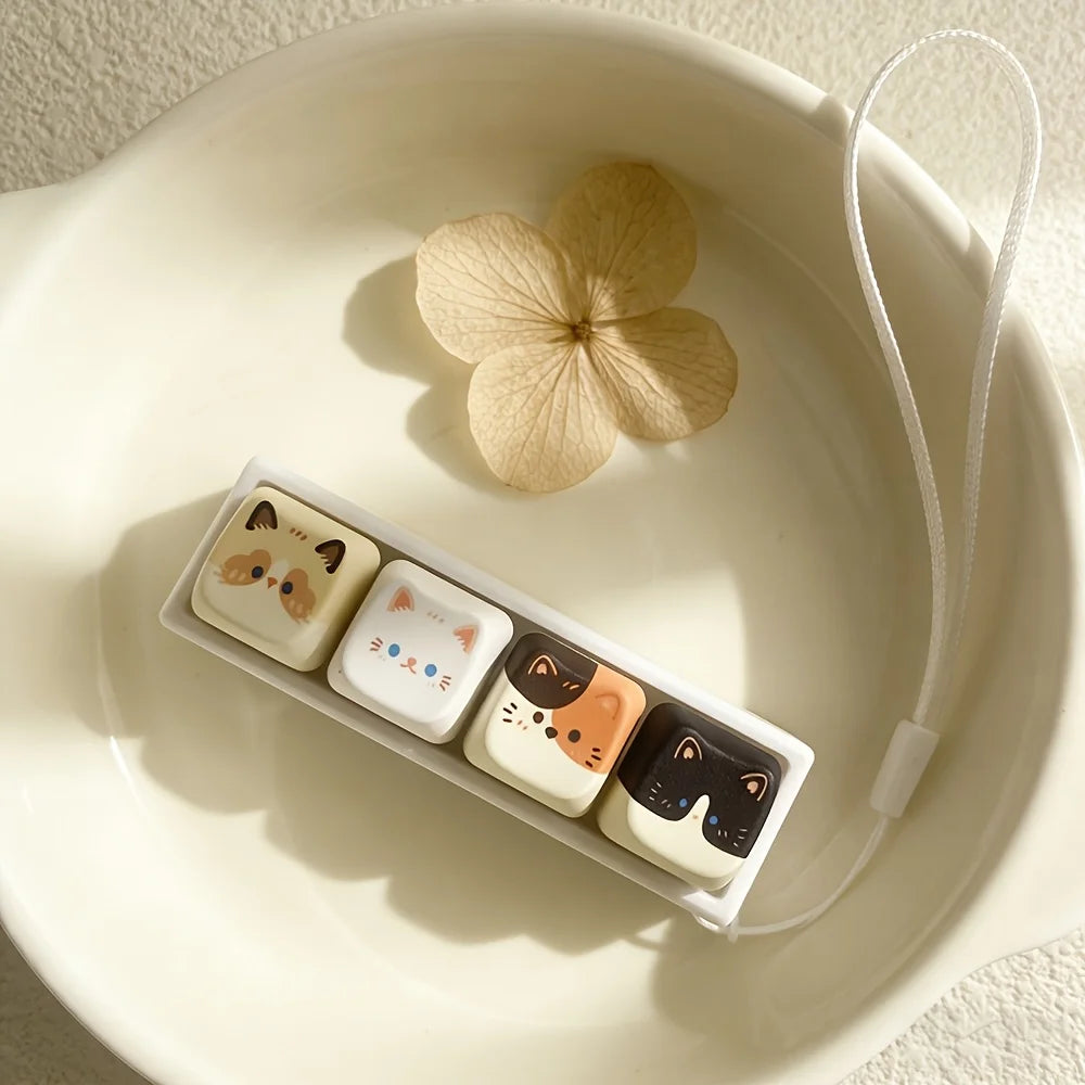 Cat key lanyard with illustrated cat buttons placed in a white bowl with a dried flower