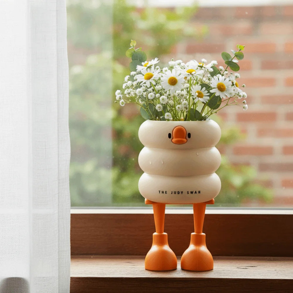 Duck-shaped organizer with orange feet used as a flower vase on a window sill