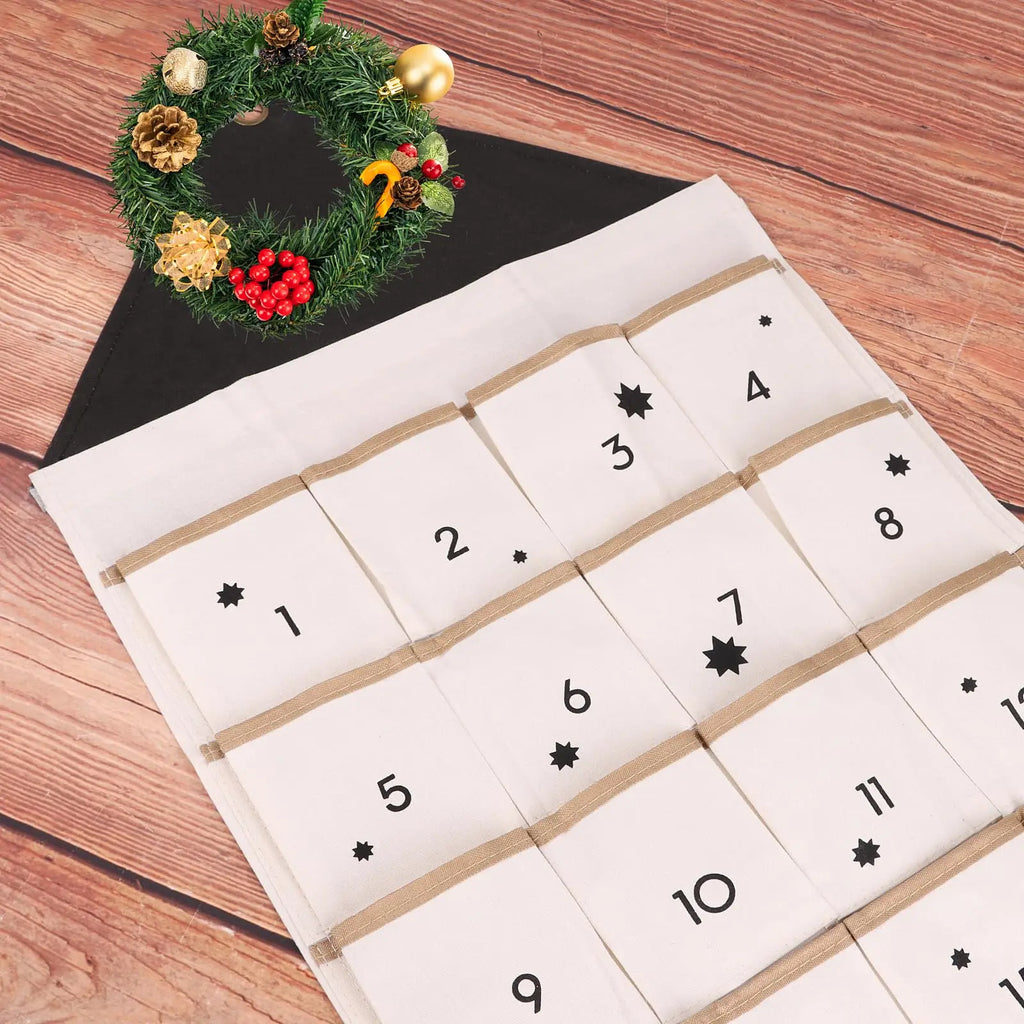 black-topped cloth advent calendar with numbered pockets and a decorative holiday wreath