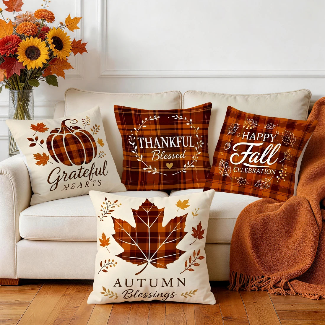 Fall plaid pumpkin and maple leaf pillowcases styled on a living room sofa with an orange throw blanket and autumn flowers.