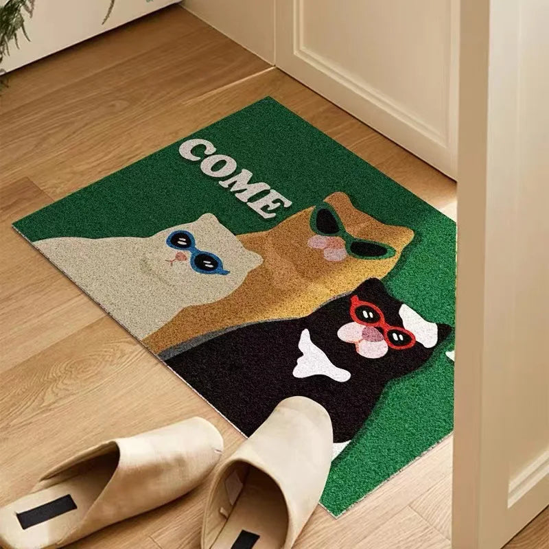 funny cat doormat placed indoors by an entryway door with slippers