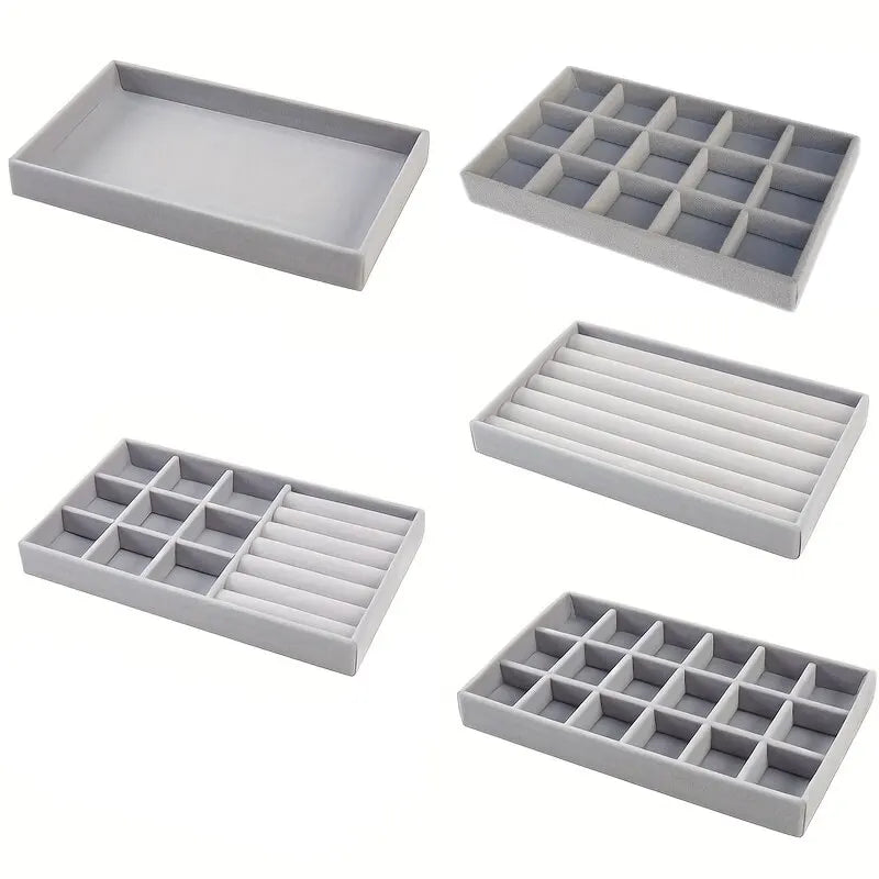 Five soft grey velvet jewelry organizer trays in different compartment layouts for rings, earrings, and small accessories