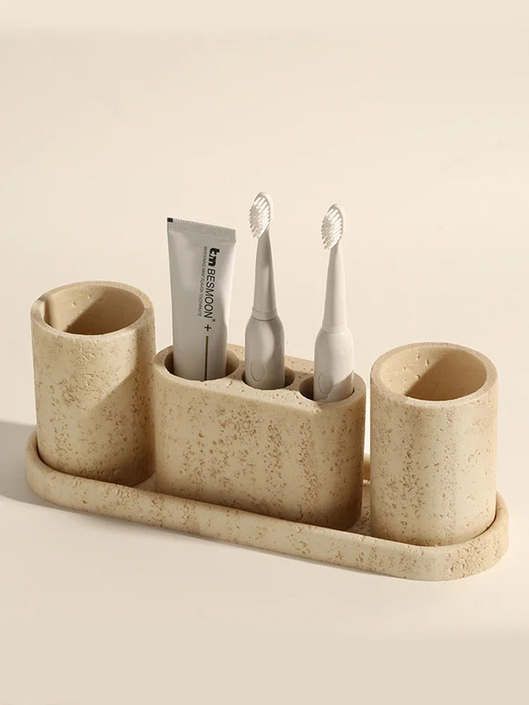 Oval travertine toothbrush holder with compartments for brushes and toothpaste