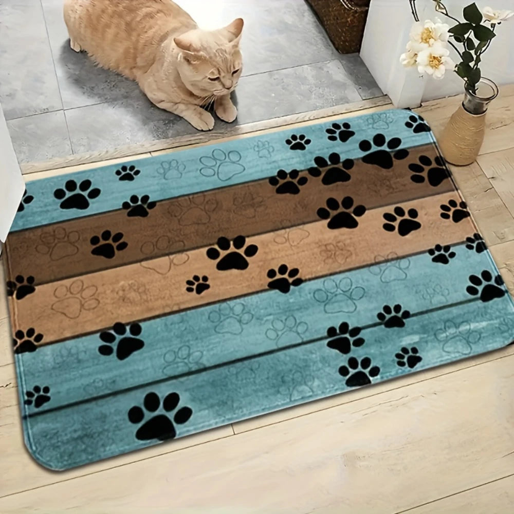 Cat beside a blue and brown striped paw print doormat on an indoor floor