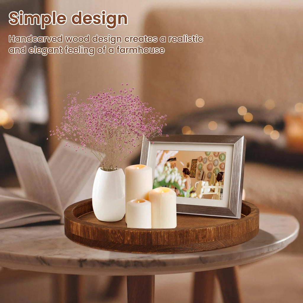 Round wooden tray styled on coffee table with candles, vase, and photo frame