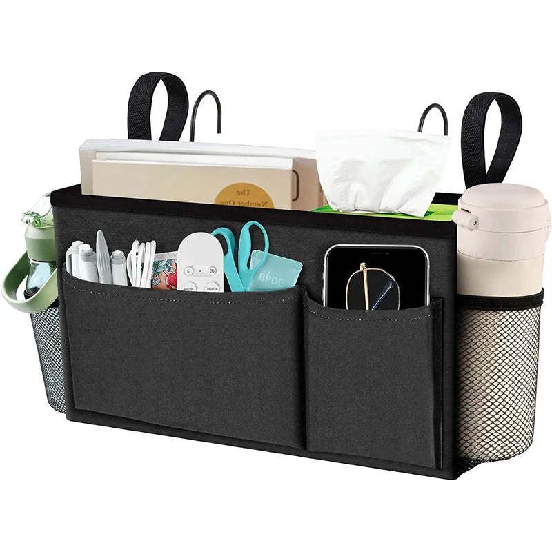 Front view of black bedside caddy organizer filled with books, a phone, water bottle, and small essentials
