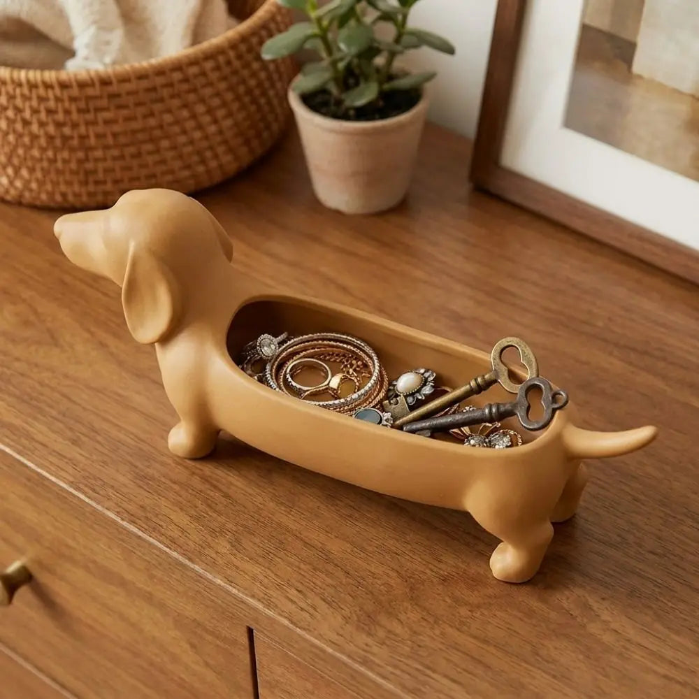 Brown dachshund catchall tray with jewelry and keys on a wood dresser