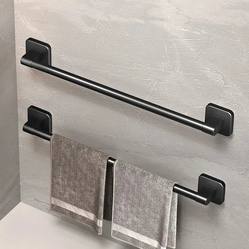 two black wall-mounted towel racks on a bathroom wall with towels hanging