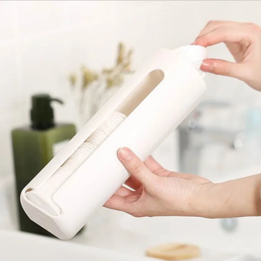 Hands refilling a white cotton pad holder with facial cotton pads next to a bathroom sink