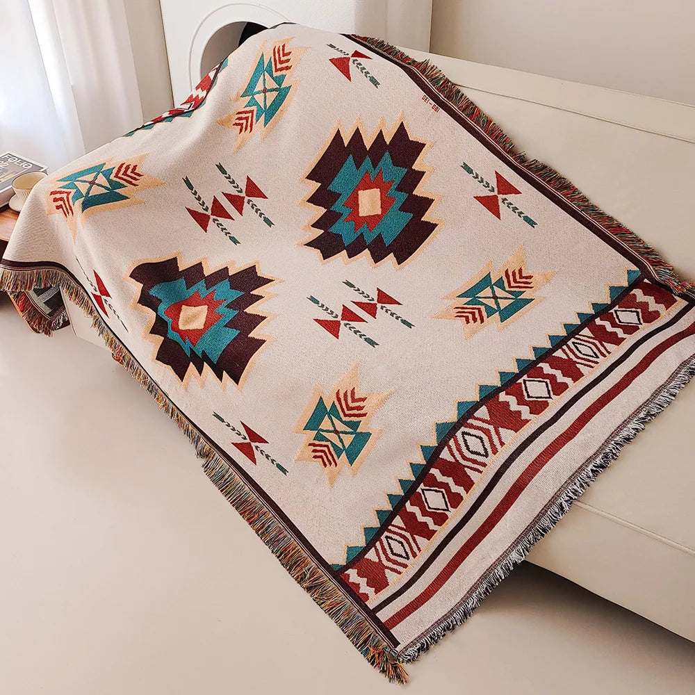 Aztec fringe throw blanket draped over a modern sofa, geometric south-western pattern visible