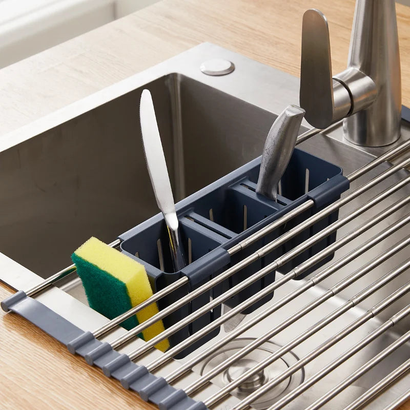 Expandable over-sink drying rack with cutlery and sponge holders in use over a kitchen sink